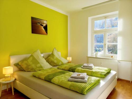 インメンシュタット・イム・アルゴイにあるTop! Wohnung direkt am Fuß der Berge im Oberallgäuの緑のベッドルーム(タオル付きのベッド付)
