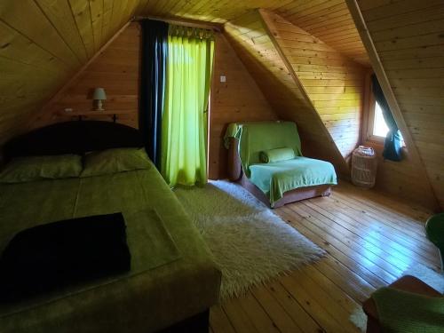 a attic bedroom with a bed and a window at Brvnara Borovik in Cetinje