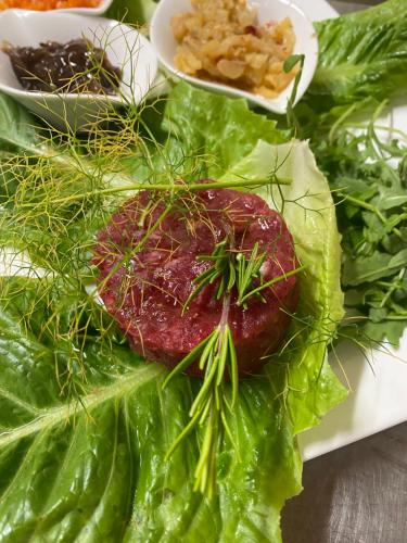 a plate of food with a piece of meat on lettuce at Lo Scoiattolo Country House in Montorio al Vomano