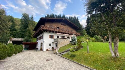 a large house with a wooden roof at Pension Hattinger in Maria Alm am Steinernen Meer