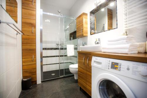uma casa de banho com uma máquina de lavar roupa e um chuveiro em Bochenka Apartments na Cracóvia
