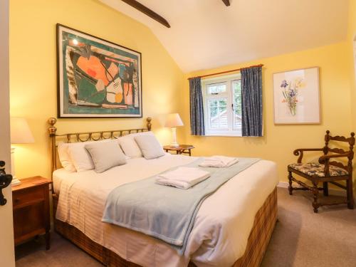 sypialnia z dużym łóżkiem i oknem w obiekcie The Stable w mieście Lyme Regis