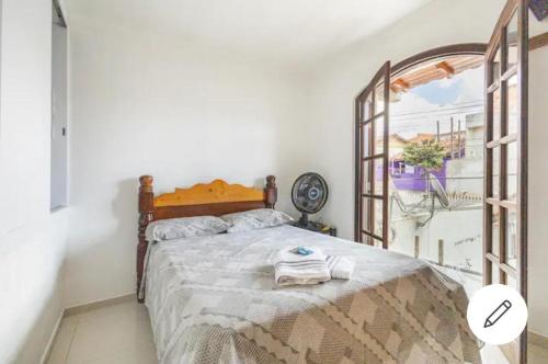 a bedroom with a bed with a large window at Casa da Família Anton in São José dos Pinhais