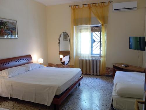 a bedroom with two beds and a mirror and a window at Lucia's apartaments in Bari Palese
