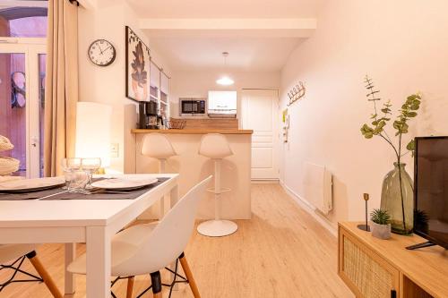 une cuisine et un salon avec une table et des chaises blanches dans l'établissement love cocoon with beautiful terrace, à Toulouse