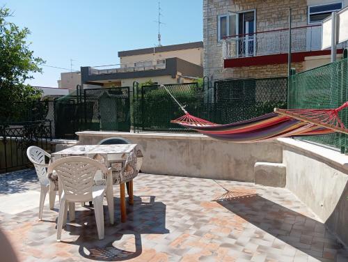 a hammock and a table and chairs on a patio at Lucia's apartaments in Bari Palese