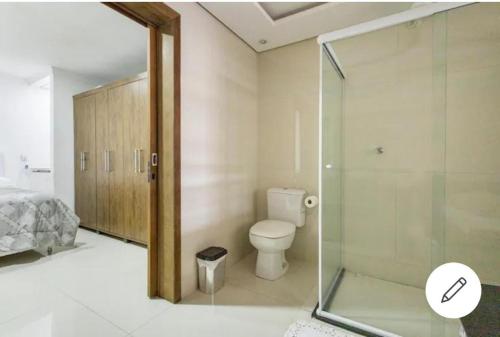 a bathroom with a toilet and a glass shower at Quarto em Casa da Família Anton in São José dos Pinhais