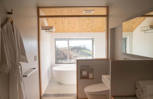 ein Bad mit einer Badewanne und einem großen Fenster in der Unterkunft sailor's house - Vacation STAY 77417v in Wajima