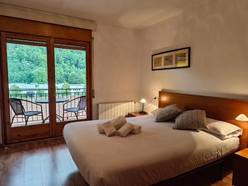 een slaapkamer met een groot bed en een balkon bij Allotjaments Bruc in Camprodon