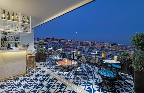 a balcony with tables and chairs and a view of a city at H10 Duque de Loule in Lisbon