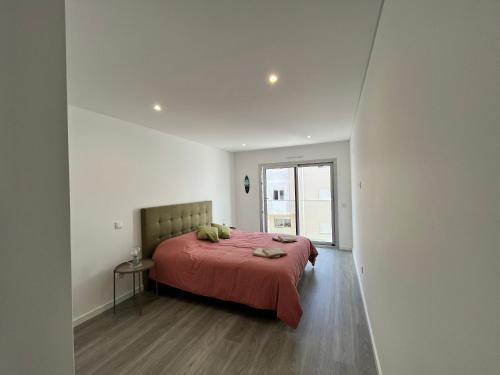 a bedroom with a large bed with a red blanket at Luxury flat with ocean view Nazaré Sitio in Nazaré