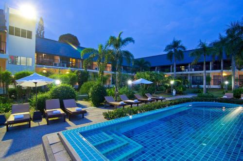 een zwembad met ligstoelen en een hotel bij Sunshine Garden Resort in Noord Pattaya