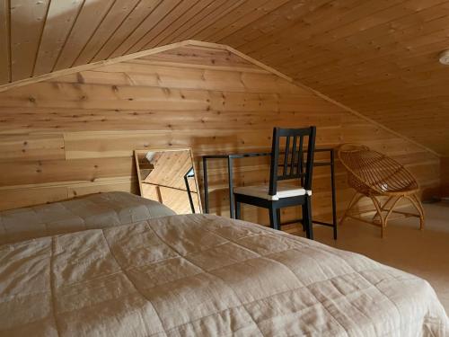 a bedroom with a bed and a wooden wall at Ylläs Seita cottage in Kittilä