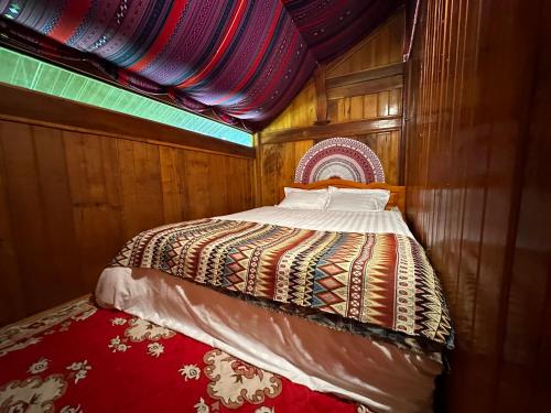 a small bed in a wooden room with a canopy at Lanh Sapa Homestay in Sa Pa