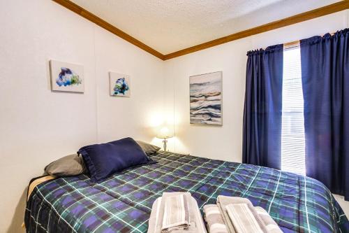 a bedroom with a bed and a window with blue curtains at Oak Harbor on Lake of the Woods & Rainy River in Baudette