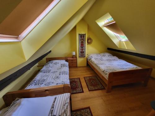 ブレンナにあるApartament Buczynaのベッド2台と窓が備わる屋根裏部屋です。