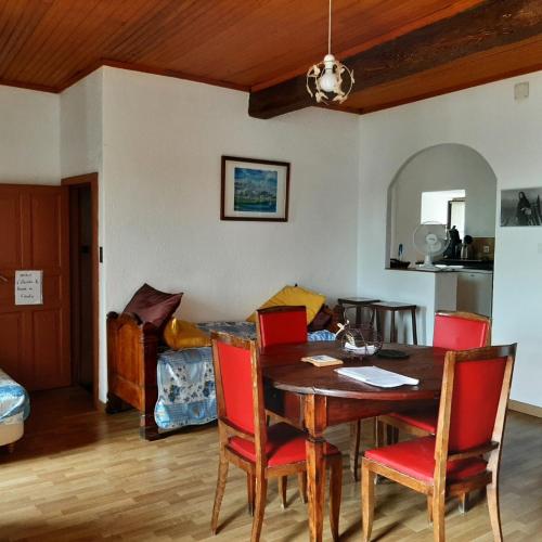 une salle à manger avec une table et des chaises rouges dans l'établissement Appartement 3 pièces 80 m2 Quenza, à Quenza