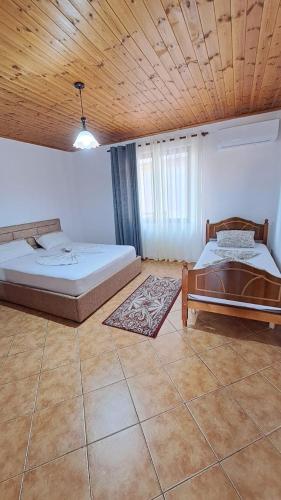 a bedroom with two beds and a wooden ceiling at Appartamento vicino al centro storico in Shkodër