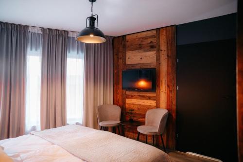 a bedroom with a bed and a table and chairs at SLEEP WELL 1999 in Tychy