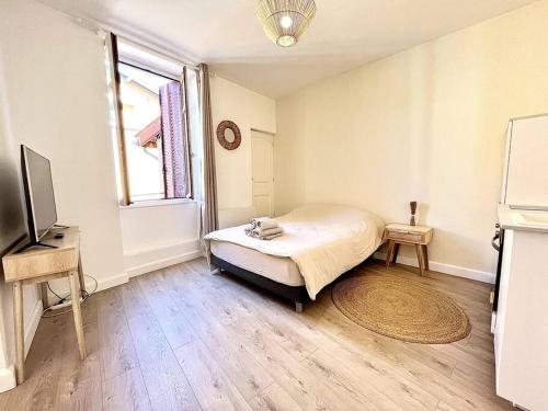 une chambre avec un lit, une télévision et une fenêtre dans l'établissement Le Nacre 18 - Bourg-de-Péage, à Bourg-de-Péage