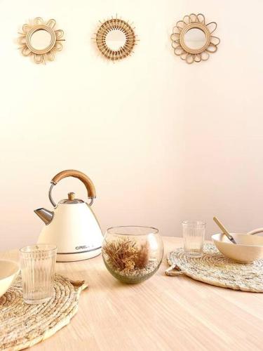 - une table avec une bouilloire et un bol de nourriture dans l'établissement Le Nacre 18 - Bourg-de-Péage, à Bourg-de-Péage