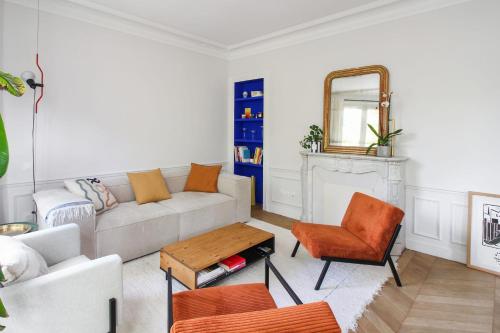 salon z kanapą i lustrem w obiekcie Wonderful flat in Paris - Welkeys w Paryżu