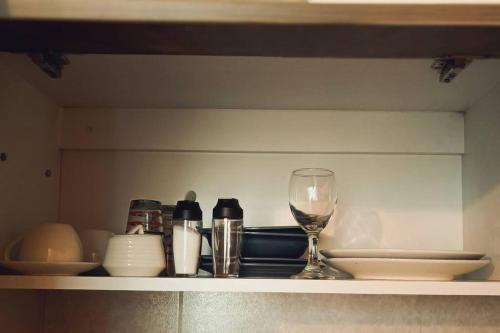 a shelf with a wine glass and other items on it at MINI DEPARTAMENTO independiente, privado y cómodo in Arequipa