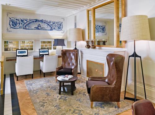 a living room with chairs and a fireplace at H10 Duque de Loule in Lisbon