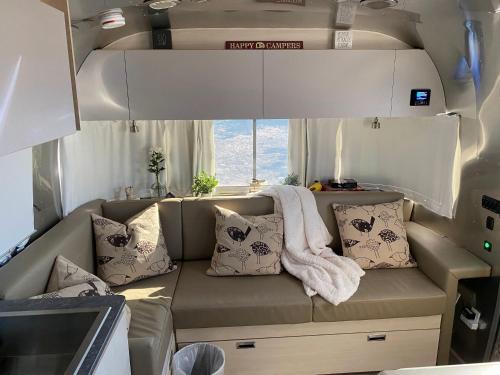 an interior of an rv with a couch and pillows at Airstream Alfresco in Fredericksburg