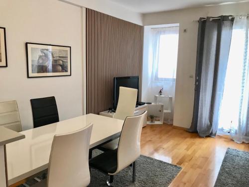 a dining room with a white table and chairs at First Choice Apartment in Skopje