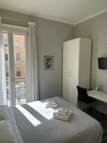 羅馬的住宿－The Manzoni，一间卧室配有一张床、一张书桌和一个窗户。