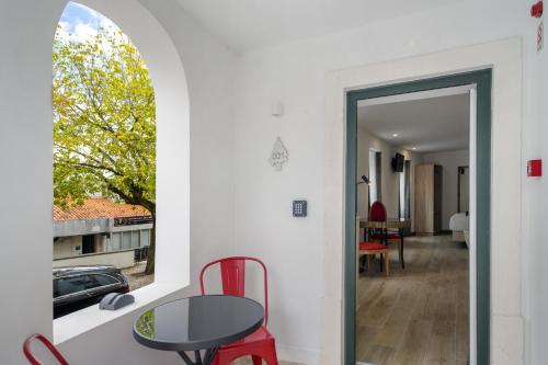 a room with a table and chairs and a window at FOREST VILLAS - GUEST HOUSE in Leiria