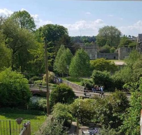 un groupe de personnes se promenant autour d'un parc avec un pont dans l'établissement Millstream House, à Winchester