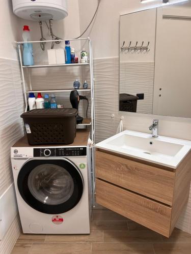 een badkamer met een wasmachine en een wastafel bij Gold sand in Cagliari