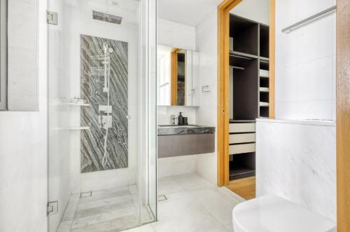 a bathroom with a shower and a toilet and a sink at The Modern Loft 1BR in Singapore! in Singapore