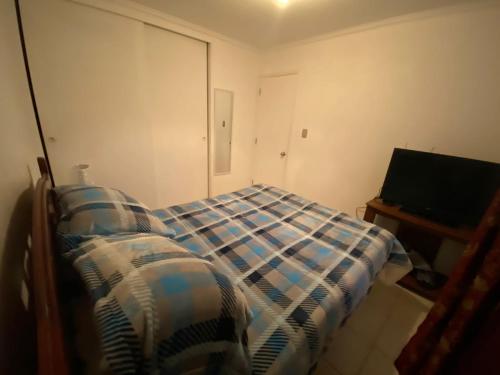 - une chambre avec un lit et une télévision à écran plat dans l'établissement Condominio Pinares del Canelillo, à Algarrobo