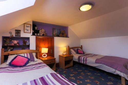 1 dormitorio con 2 camas y 2 lámparas en Super Spacious Country house pet/party friendly., en Newquay