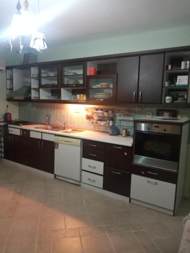 a kitchen with black cabinets and white appliances at Paradise Manavgat in Manavgat