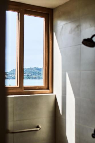 a bathroom with a sink and a window and a shower at Hotel Basalto in Punta Mita