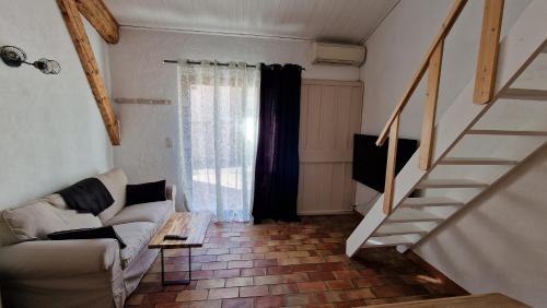 a living room with a staircase and a couch at Studio Au Pied De La Sainte Victoire in Puyloubier
