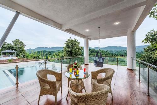 a patio with a table and chairs and a pool at SaffronStays Ivory Mansion in Pen