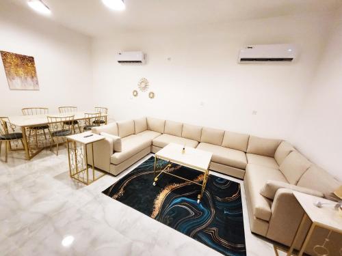 a living room with a couch and a table at Moods Holiday Homes in Al Ain