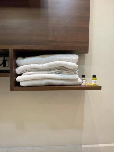 a stack of towels on a shelf in a bathroom at Vishwanath Inn in Varanasi