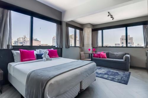 a bedroom with a large bed with pink pillows at Housi Bela Cintra in São Paulo