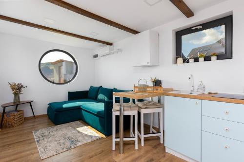 a living room with a blue couch and a table at Zen Nest Tiny House in Şirnea