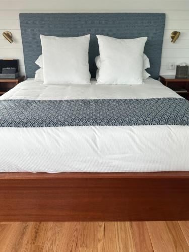 a bed with a blue headboard and white pillows at Harborside Inn in Newport