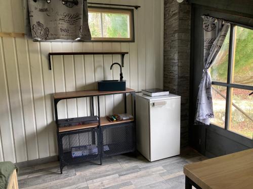 Cette chambre comprend un petit réfrigérateur et une table. dans l'établissement Charmant petit dortoir 3 places, à Chazelles