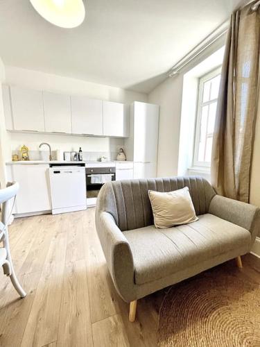 un salon avec un canapé et une cuisine dans l'établissement Le Nacre 17 - Bourg-de-Péage, à Bourg-de-Péage