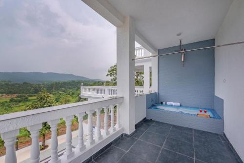 a balcony with a hot tub on the side of a house at SaffronStays Ivory Mansion in Pen