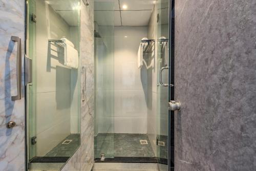 a shower with a glass door in a bathroom at SaffronStays Ivory Mansion in Pen